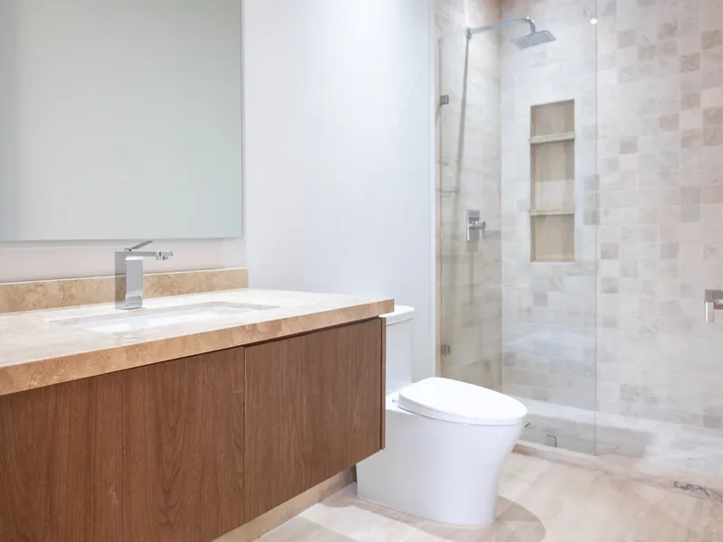 Baño de Casa Roqueño 68 con mueble de madera y regadera de piedra